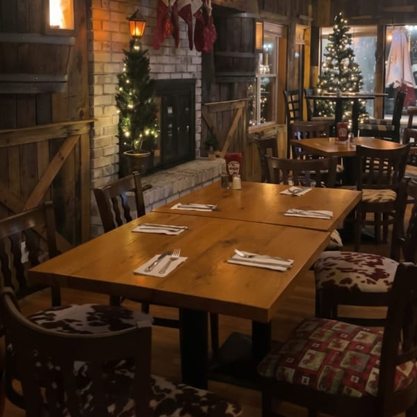 Cozy, rustic dining room at The Clam Bar with wooden tables, patterned chairs, and Christmas decorations.